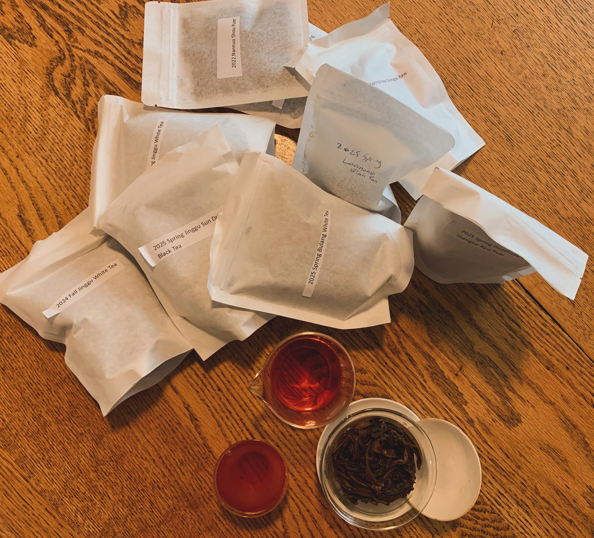 Tea bags for tea club box and a cup of tea on a wooden surface